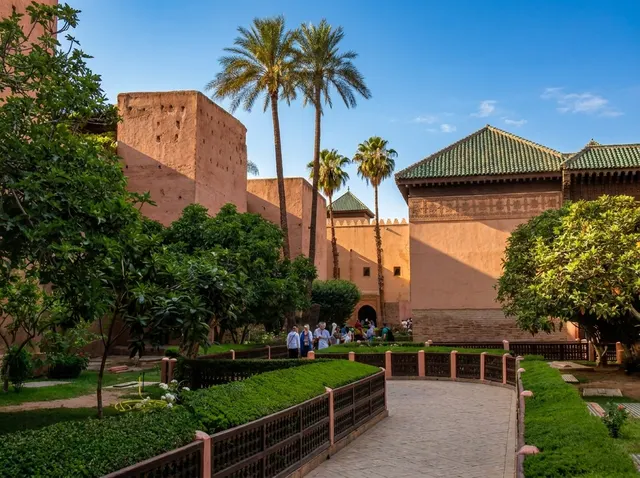 The garden of the Saadian Tombs with palms, pisé walls and the green-tiled mausoleum roofs
