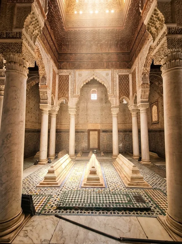 Light from the lantern falling on three marble tombs between the columns of the main chamber